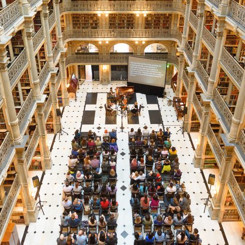 A seated audience in the Peabody Library