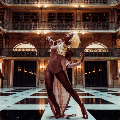 Woman in a dancing pose in Peabody Library