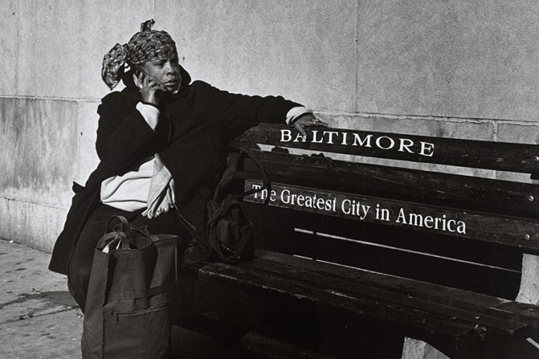 photo of a woman sitting on a baltimore bench